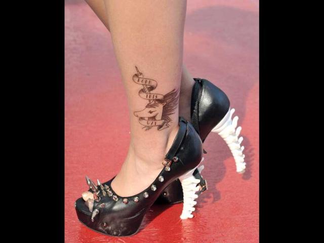 A fan of US pop diva Lady Gaga sports a pair of shoes and a tattoo similar to one her idole wears, as she poses before her concert in Hong Kong. AFP Photo/Laurent Fievet