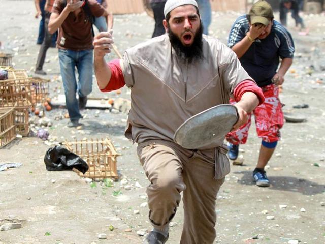 An Egyptian anti-military protester reacts as he is struck by a rubber bullet in the eye during clashes in the Abbassiya district of Cairo. Thugs attacked an anti-military protest near the defence ministry in Cairo and at least 20 people were killed, officials said, in the politically tense run-up to the first post-uprising presidential election. AFP PHOTO/KHALED DESOUKI