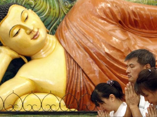 Buddhist devotees offer prayers in front of a Buddha statue during Wesak Day, known as Buddha's birthday, at Buddhist Maha Vihara Temple in Kuala Lumpur, Malaysia. (AP Photo/Lai Seng Sin)