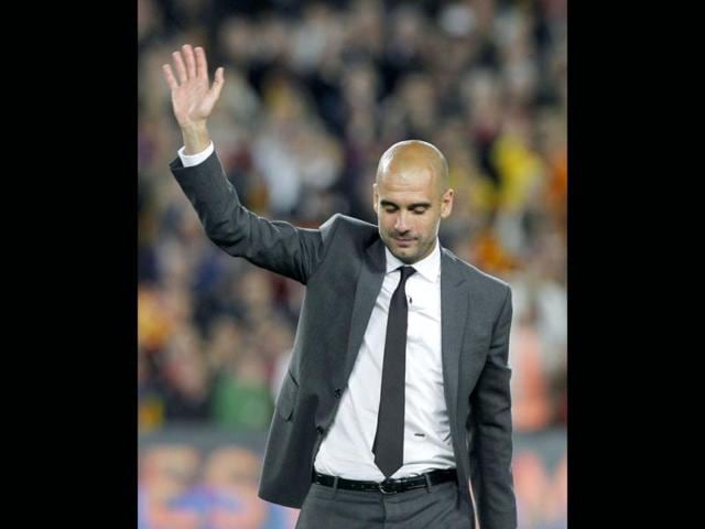 Barcelona's coach Pep Guardiola salutes the crowd as he leaves the pitch after his last match at Camp Nou stadium in Barcelona. (Reuters/Albert Gea)