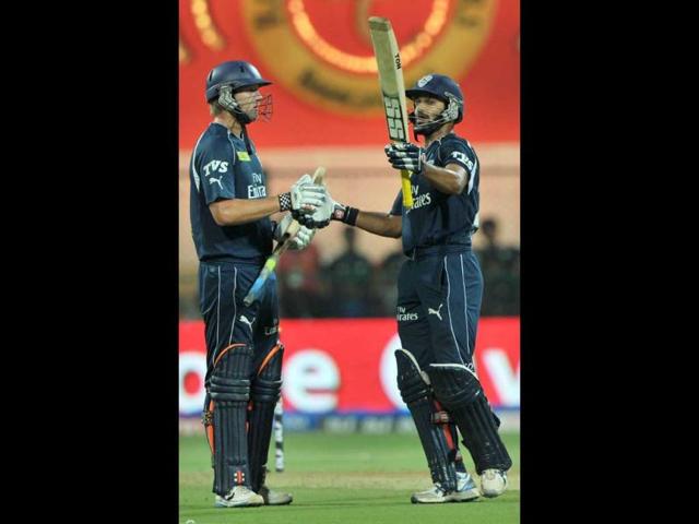 Deccan Chargers batsman Shikhar Dhawan (R) raises his bat to celebrate fifty runs while his team mate Cameron White looks on during the IPL Twenty20 cricket match between Royal Challengers Bangalore and Deccan Chargers at the M. Chinnaswamy Stadium in Bangalore. AFP Photo/Manjunath Kiran