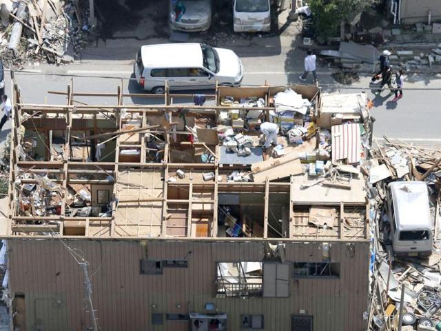 People clean the debris inside a building where its roof was blown by a tornado in Tsukuba, northeast of Tokyo. AP Photo/Kyodo News