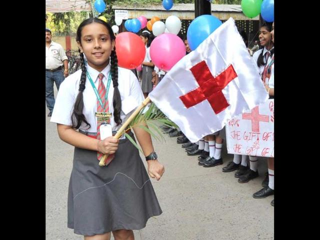A girl holding a flag at Kargil Crossing in Patna during celebratiion of World Red Cross Day. Agencies