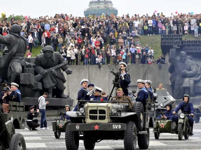 Ukrainian soldiers dressed in Soviet-era uniforms ride in vintage military vehicles during celebrations of the Victory Day at the World War II memorial in Kiev, Ukraine. AP/Sergei Chuzavkov