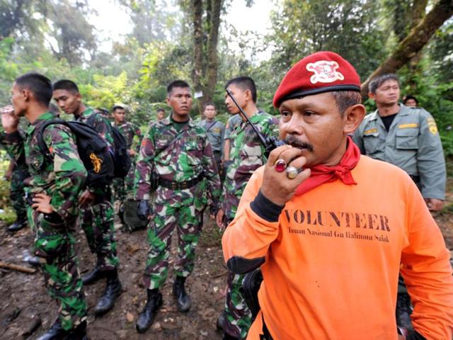 Indonesian soldiers along with members of a search and rescue team search the location of the Russian Sukhoi Superjet plane crash in Cidahu. The wreckage of a Russian Sukhoi Superjet was found on the side of a dormant Indonesian volcano, a day after it disappeared during a demonstration flight with about 50 people aboard. AFP Photo / Adek Berry