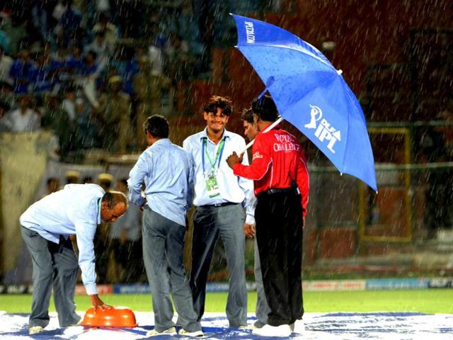 Ground staff cover the pitch as it rains during a IPL match between Rajasthan Royals and Chennai Super Kings at Sawai Mansingh stadium in Jaipur. AFP/Prakash Singh