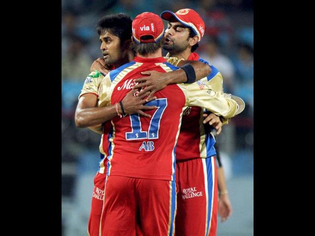 Vinay Kumar (L) is congratulated by teammates AB De Villiers (C) and Virat Kohli after he took the wicket of Pune Warriors India batsman Michael Clarke during the IPL Twenty20 cricket match in Pune. AFP/Indranil Mukherjee