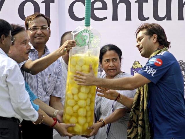 Chief Minister of West Bengal Mamata Banerjee presents a cricket bat-shaped container filled with Rasgolla to Sachin Tendulkar during a felicitation at Eden Gardens in Kolkata. (AP Photo/Bikas Das)