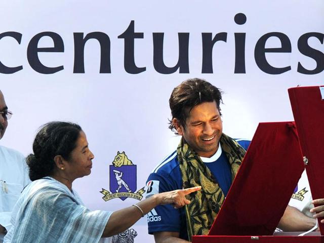 he chief minister of West Bengal Mamata Banerjee looks on as other offical give gifts to cricketer Sachin Tendulkar for his achievement of a hundred centuries in international cricket ahead of the IPL Twenty20 cricket match between Kolkata Knight Riders and Mumbai Indians at The Eden Gardens in Kolkata. (AFP photo/Dibyangshu Sarkar)