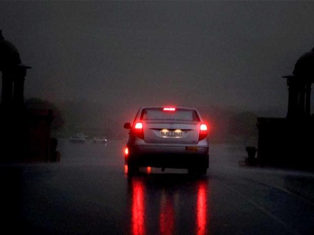 A vehicle moves at Raisina Hill as visibility gets poor during rains in New Delhi. PTI/Shahbaz Khan