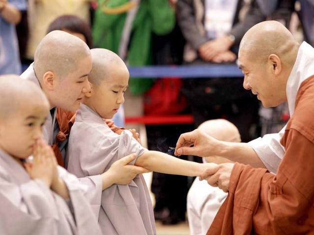 Shaven-headed young boys participate at a service to celebrate Buddha's upcoming birthday at Jogye temple in Seoul, South Korea. Nine children entered the temple to have an experience of monks' life for three weeks, called Little Buddha Camp. AP Photo/Lee Jin-man