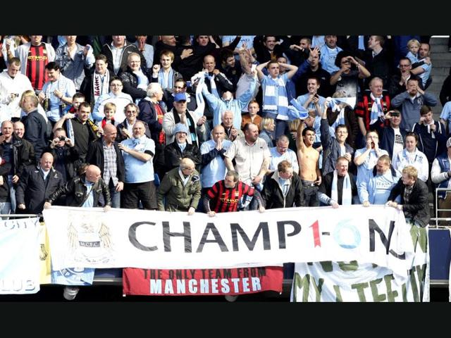 Manchester City fans celebrate after winning the English Premier League title after the match against Queens Park Rangers at the Etihad Stadium, Manchester, England. AP/Jon Super Manchester City fans celebrate after winning the English Premier League title after the match against Queens Park Rangers at the Etihad Stadium, Manchester, England. AP/Jon Super