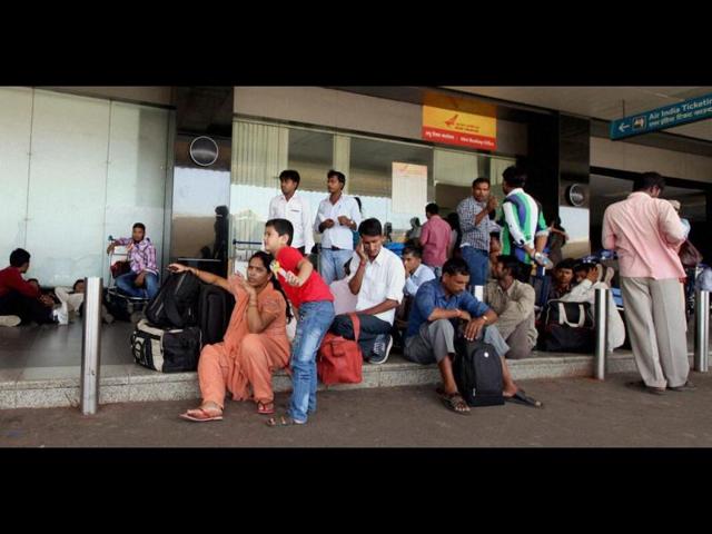 Passengers wait outside the booking office of Air India at the Mumbai International Airport following cancellation of several Air India flights. (PTI Photo)