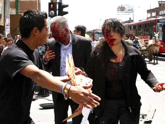 Injured people walk after an explosion in a central avenue in Bogota killing two people and injuring a former interior minister who was the target, President Juan Manuel Santos said. Reuters