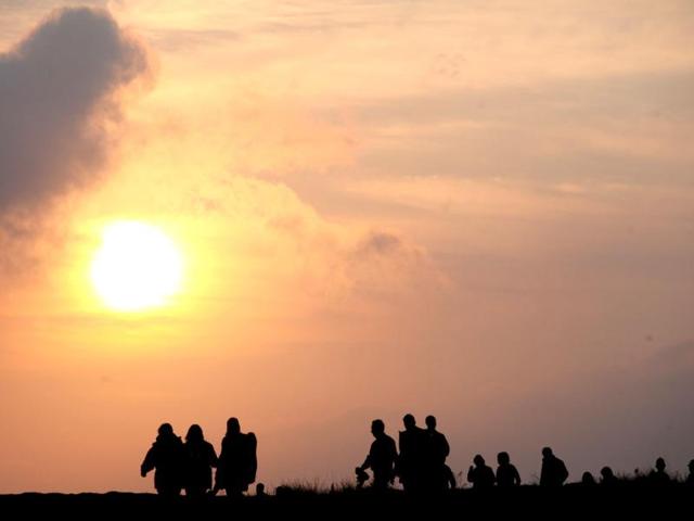 Members of the public trek across rough ground to watch the official start of the London 2012 Olympic games torch relay at Land's End, south west England. AP/Alastair Grant
