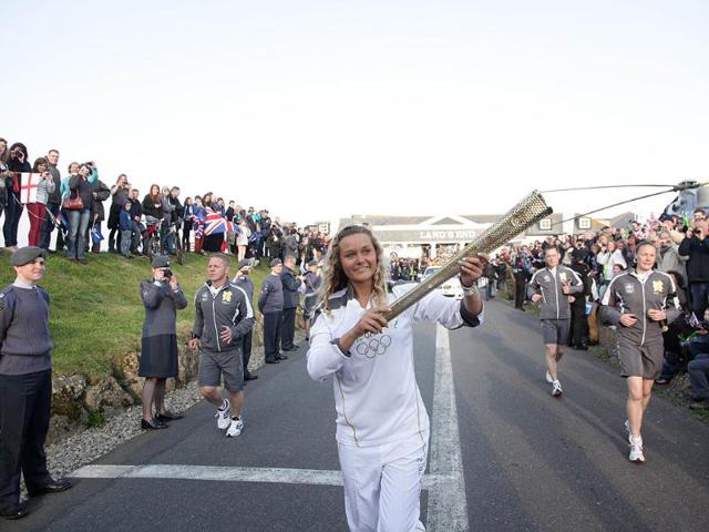 Anastassia Swallow (C), the second torchbearer runs holding the Olympic flame at Land's End, the southwesterly tip of England at the start of the torch relay around Britain and Ireland. AFP photo