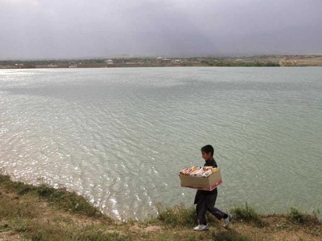 A boy sells biscuits as he walks along a lake in Kabul. Reuters/Mohammad Ismail