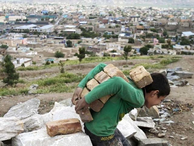 An Afghan boy carries bricks on his back in Kabul, Afghanistan. AP/Rahmat Gul