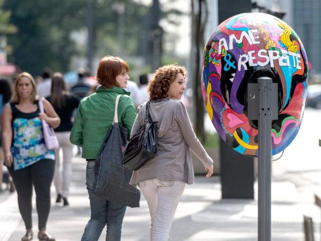 Women look at a decorated public phone booth in Sao Paulo, Brazil. A hundred phone booths, nicknamed Orelhao (meaning 'big ear' in Portuguese), are being replaced with art works by a local phone company. AFP/Yasuyoshi Chiba
