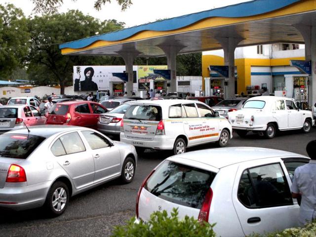 People line up to fill their vehicles at an oil pump in New Delhi after the announcement of hike in petrol prices. PTI/Kamal Singh