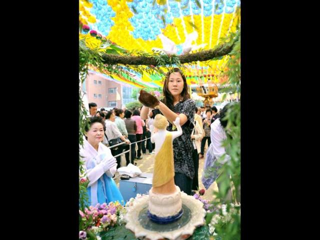 South Korean Buddhist followers pour water on a small statue of Buddha during a ceremony to celebrate the 2,556th birthday of Buddha at Jogye temple in Seoul. (AFP Photo)