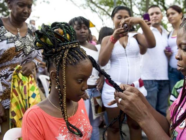 A woman gets an African-Colombian hairstyle during the 8th contest of Afro-hairdressers, in Cali, Valle del Cauca departament, Colombia. AFP Photo/Luis Robayo