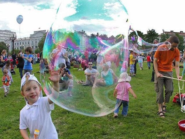 People participate soap bubble gathering in Vilnius during the "Burbuliatorius," which takes place every second Monday in summer time in more than 15 world cities. AFP/Petras Malukas
