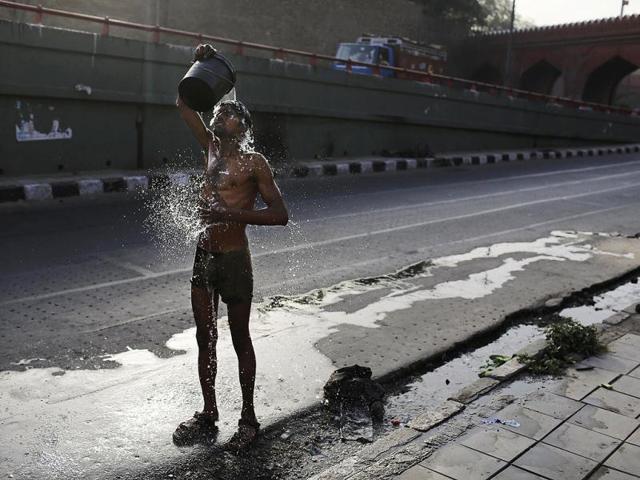 A labourer takes a bath on a hot morning in New Delhi. AP Photo/Kevin Frayer
