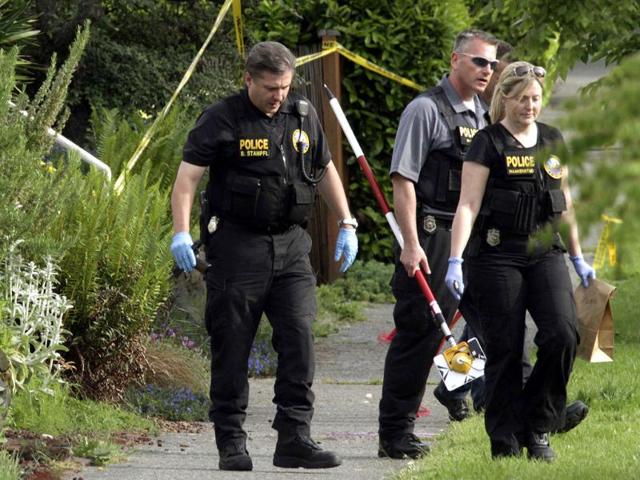 Seattle Police Department crime scene investigators remove a gun (in hand of officer on left) from a crime scene in a West Seattle neighborhood where a gunman shot himself after being confronted by police in Seattle, Washington May 30, 2012. REUTERS/Marcus Donner