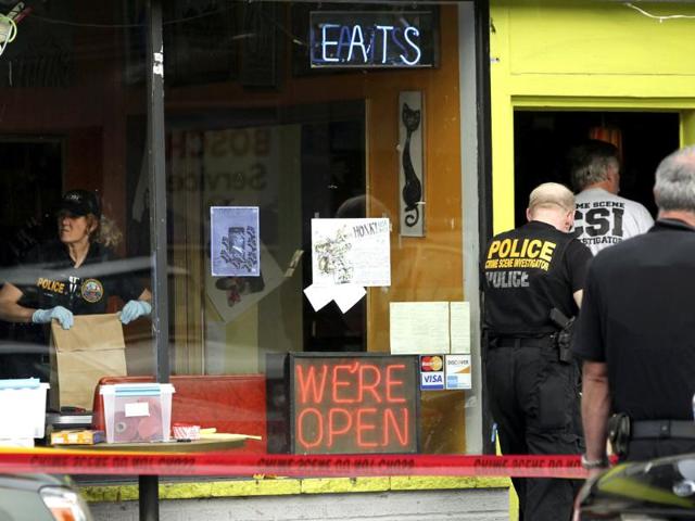 Crime scene investigators continue their investigation at Cafe Racer in North Seattle, where earlier a gunman shot two men and a woman to death, May 30, 2012. The shooter then fled South to a downtown Seattle parking lot, where he fatally shot another woman and stole her car before shooting himself when police closed in to confront him in West Seattle, authorities said. The suspect, who was not immediately identified, was being treated for a self-inflicted gunshot wound to the head at Harborview Medical Center following the two late-morning slayings, which police initially treated as separate incidents. REUTERS/Anthony Bolante