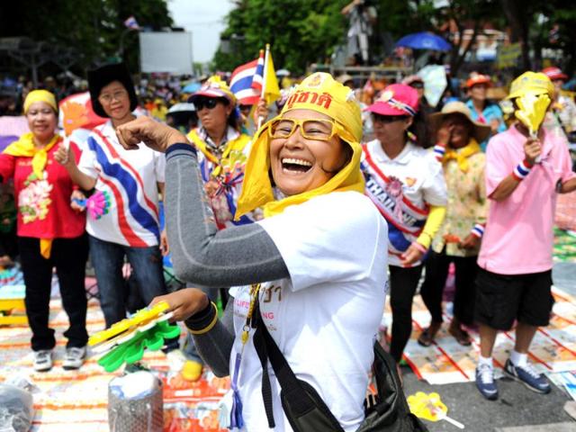 A member of the royalist Yellow Shirts dances during a protest against a proposed reconciliation debate, outside the parliament in Bangkok. AFP/Aaron Tam