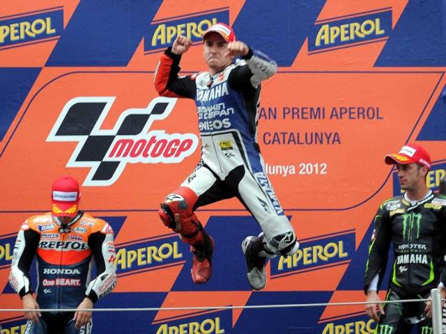 Yamaha Factory Racing's Spanish Jorge Lorenzo (C) celebrates on the podium after winning the MotoGP race of the Catalunya Moto GP at the Catalunya racetrack in Montmelo, near Barcelona. Yamaha Factory Racing's Spanish Jorge Lorenzo won the race ahead of Repsol Honda Team's Spanish Dani Pedrosa (L) and Monster Yamaha Tech 3 Italian Andrea Dovizioso (R). AFP/Lluis Gene