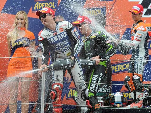 Yamaha Factory Racing's Spanish Jorge Lorenzo (L), Monster Yamaha Tech 3 Italian Andrea Dovizioso (C) and Repsol Honda Team's Spanish Dani Pedrosa (R) celebrate on the podium after the MotoGP race of the Catalunya Moto GP at the Catalunya racetrack in Montmelo, near Barcelona. AFP/Lluis Gene