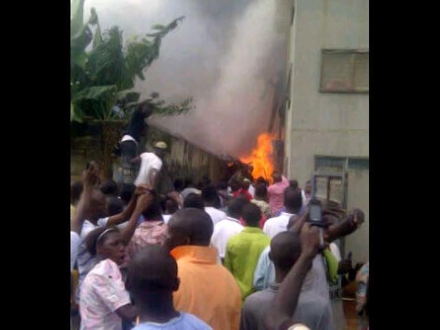 A picture taken with a photo camera shows residents of the Iju district of Lagos rushing a few moments after a Dana company aircraft crashed into a two-storey building on June 3, 2012 in Lagos. AFP PHOTO / CKN