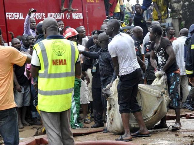 The bodies of victims are carried from the scene of a plane crash in Nigeria's commercial capital Lagos, June 3, 2012. A passenger plane carrying nearly 150 people crashed into a densely populated part of Lagos on Sunday, in what looked like a major disaster in Nigeria's commercial hub. There was no early word from airline or civil aviation authority officials in the West African country on casualties. REUTERS/Stringer