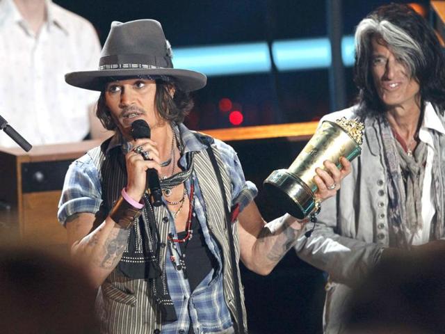 Johnny Depp (L) accepts the MTV Generation Award as presenter Joe Perry of Aerosmith watches on at the 2012 MTV Movie Awards in Los Angeles. Reuters/Mario Anzuoni