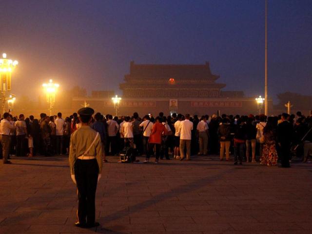 A paramilitary policeman watches over a crowd gathered to watch the raising of the Chinese national flag on Beijing's Tiananmen Square. Reuters/David Gray