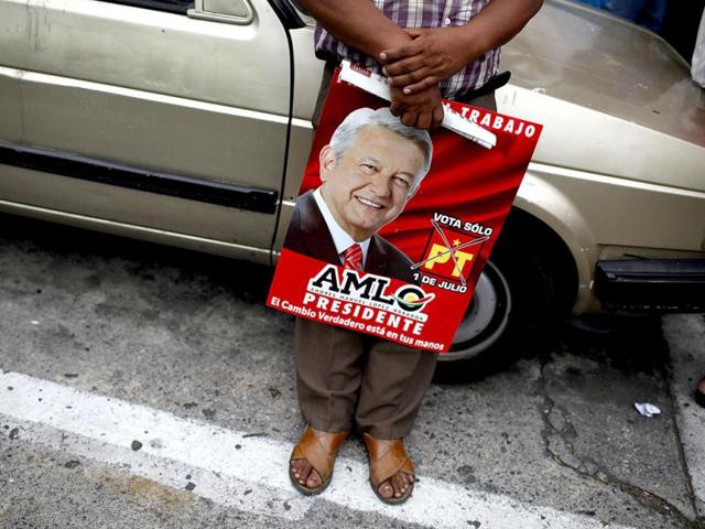 A man holds a poster of Andres Manuel Lopez Obrador, presidential candidate for the Party of the Democratic Revolution (PRD), during a rally in Orizaba, in the Mexican State of Veracruz. Reuters Photo/Tomas Bravo