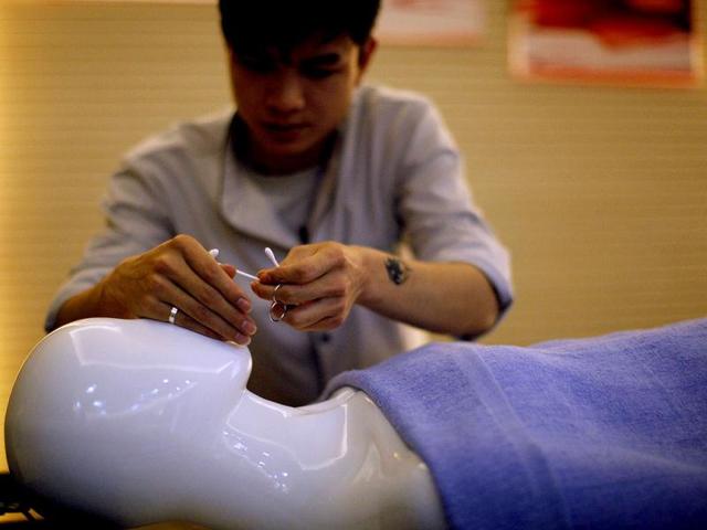 A student practices with a mannequin during their undertaker service class at the Tianquanjiajing Funeral Service school in Jiaxing, Zhejiang province. A new breed of young Chinese undertakers are fighting centuries-old taboos to gain social acceptance for their profession, saying they help the deceased and their families make their final parting with respect. (Reuters)