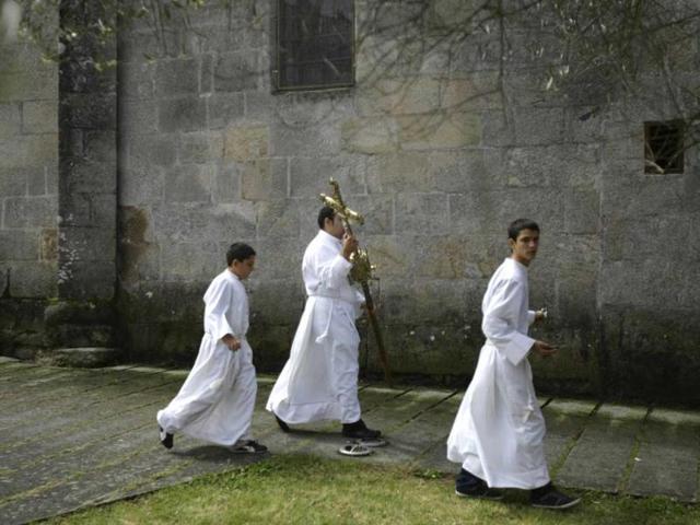 Altar servers are seen with a cross during the "Coca" celebration in Redondela, in rural northeastern Spain. (Reuters/Miguel Vidal)