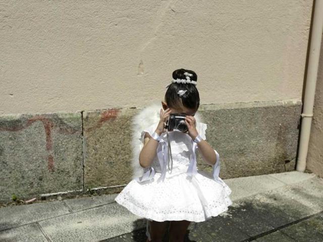 A five-year-old girl, dressed in a traditional costume called "Penlas" takes a picture during the "Coca" celebration in Redondela, in rural northeastern Spain. (Reuters/Miguel Vidal)