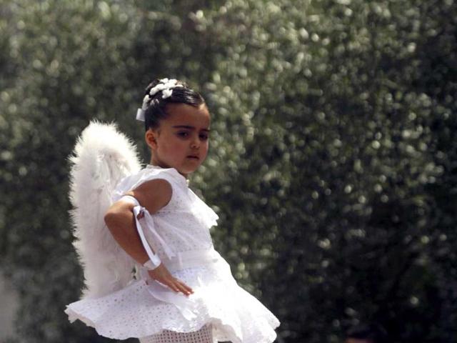 A five-year-old girl, dressed in a traditional costume called "Penlas", dances on the shoulders of a woman during the "Coca" celebration in Redondela, in rural northeastern Spain. (Reuters/Miguel Vidal)