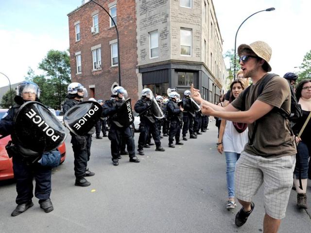 A protestor gestures towards police as he and others leave the site of a student demonstration outside a reception for the Canada Grand Prix Formula One race participants in Montreal. AFP/Stan Honda
