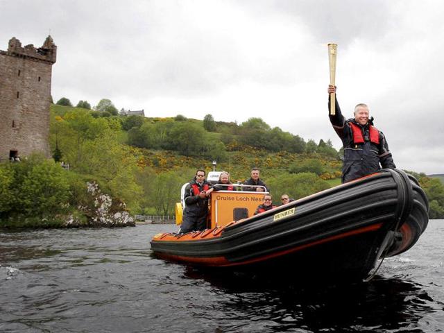 This image made available by LOCOG shows Blair Marquis holding the Olympic Torch on Loch Ness, Scotland during Day 22 of the Torch Relay. The Olympic torch crossed Loch Ness, home of the legendary monster, as part of its cross-country trek which ends at London's Olympic Park next month. (AP Photo/LOCOG)
