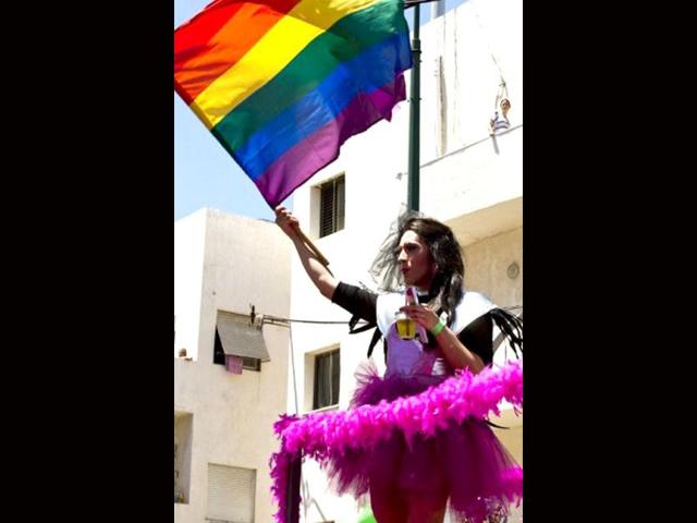 An Israeli drag queen waves a rainbow-coloured flag at the opening of the annual Gay Pride parade, where tens of thousands flooded the streets, in the Mediterranean city of Tel Aviv. AFP Photo/Jack Guez