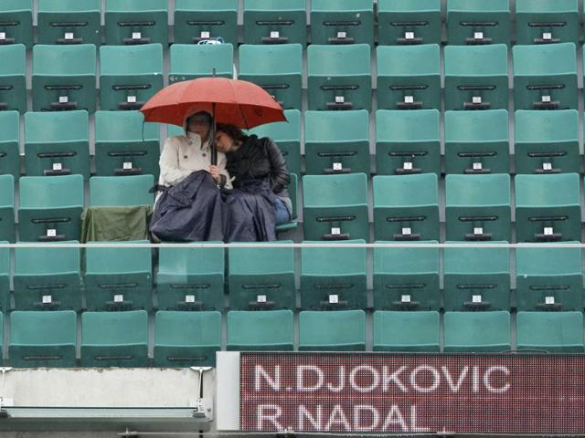 Spectators protect themselves from the rain with umbrella as rain stops the men's singles final match between Rafael Nadal of Spain and Novak Djokovic of Serbia during the French Open tennis tournament at the Roland Garros stadium in Paris Reuters/Benoit Tessier