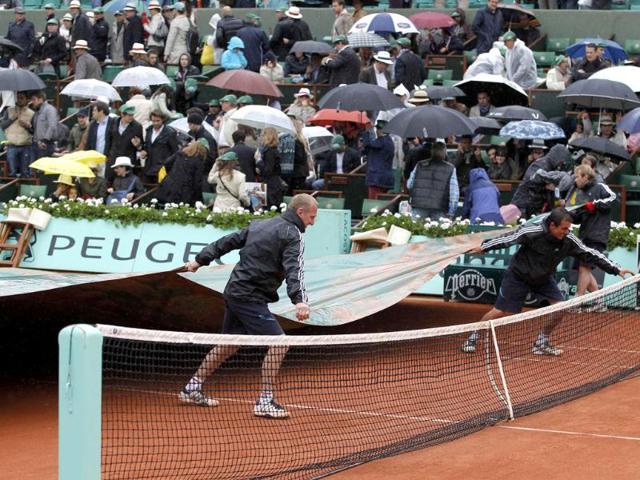 Grounds staff cover the court as rain stops the men's singles final match between Rafael Nadal of Spain and Novak Djokovic of Serbia during the French Open tennis tournament at the Roland Garros stadium in Paris Reuters/Gonzalo Fuentes