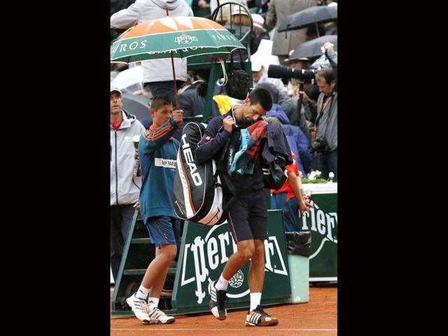 Serbia's Novak Djokovic leaves the court after the interruption of his Men's Singles final tennis match against Spain's Rafael Nadal during the French Open tennis tournament at the Roland Garros stadium, in Paris.AFP Photo/Jacques Demarthon