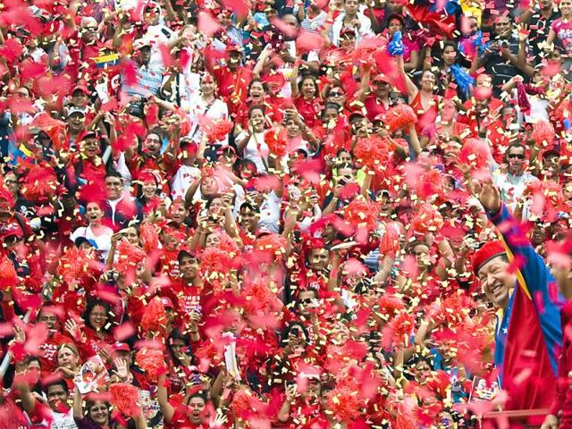 Venezuelan President Hugo Chavez (R) waves to supporters during a caravan before registering in the National Electoral Center for the upcoming presidential election, in Caracas. AFP/Leo Ramirez