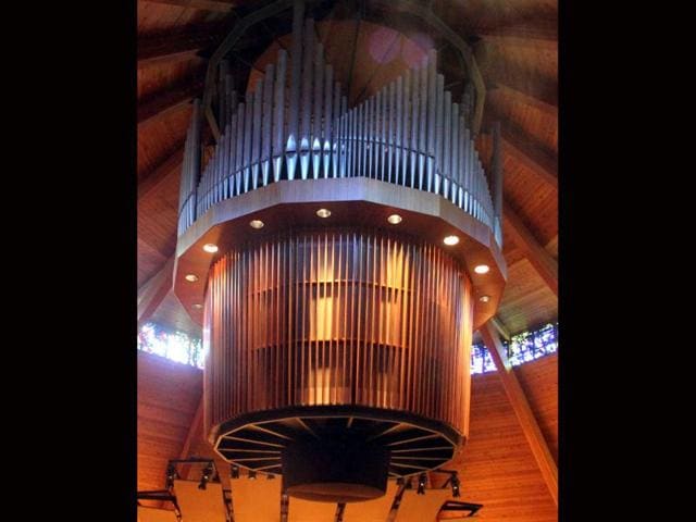 Organ pipes are suspended from the ceiling at the Agnes Flanagan Chapel Tuesday, June 12, 2012, on the campus of Lewis ' + char(38) +' Clark College, in Portland, Ore. The Agnes Flanagan Chapel is a 16-sided architectural marvel that seats 650 under stained glass windows depicting the book of Genesis. In the early 1970s, it was also a big, conical quandary. Chapels aren’t really chapels unless they have an organ, and the newly-minted structure at Portland’s Lewis ' + char(38) +' Clark College was in need. (AP Photo/Rick Bowmer)